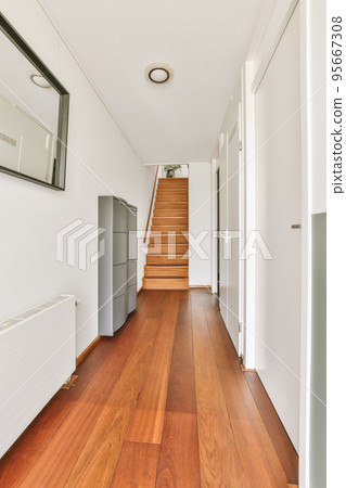 White hallway with wooden stairway leading to second floor of modern luxury apartment with minimalist interior design White hallway with wooden stairway leading to second floor of modern luxury apartment with minimalist interior design 95667308