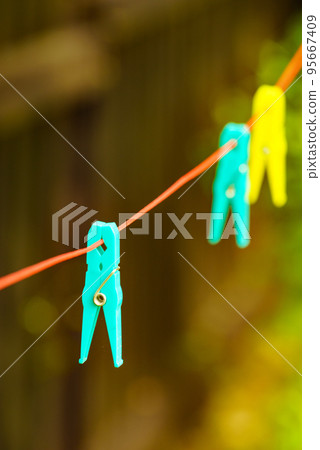 Clothes pegs on line outdoor. Housework 95667409