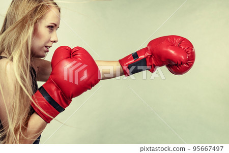Girl in red gloves playing sports boxing Girl in red gloves playing sports boxing 95667497