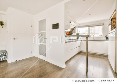 Comfortable sofa with cushions and pouf located near doors and dining area in room of contemporary apartment 95667627