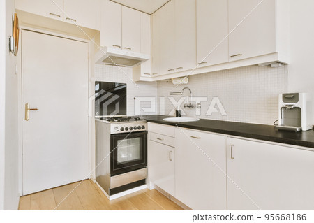 Corner cupboards and table with chairs located in light kitchen of contemporary flat 95668186