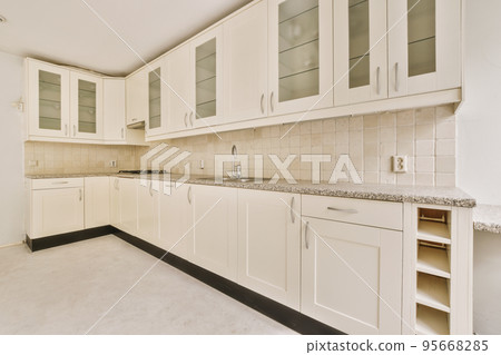 Interior of empty white kitchen with windows and wooden parquet floor Interior of empty white kitchen with windows and wooden parquet floor 95668285
