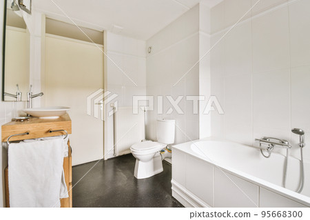 Flush toilet located between sink and shower in small tiled bathroom of contemporary apartment Flush toilet located between sink and shower in small tiled bathroom of contemporary apartment 95668300