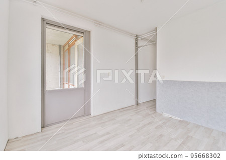 Interior of empty white room with large balcony windows with curtains and wooden parquet floor Interior of empty white room with large balcony windows with curtains and wooden parquet floor 95668302