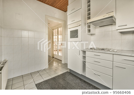 Corner cupboards and table with chairs located in light kitchen of contemporary flat 95668406
