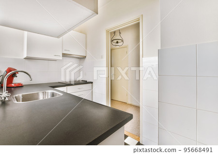 Well organized small home kitchen interior with sink under window and light furniture with stove and fridge in urban apartment Well organized small home kitchen interior with sink under window and light furniture with stove and fridge in urban apartment 95668491