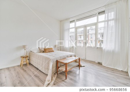 Comfortable bed and soft carpet in spacious bedroom with interior in minimal style 95668656