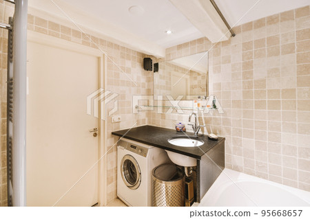 Sinks with mirrors and clean bathtub located near shower box with glass door in modern bathroom with white tiled walls 95668657