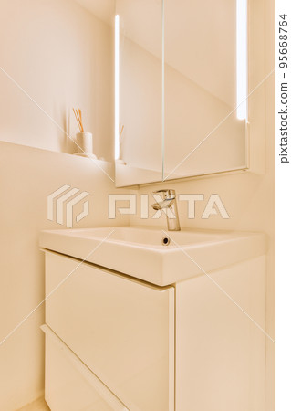 Sink with tap and liquid soap hanging on tiled wall under mirror in contemporary restroom at home Sink with tap and liquid soap hanging on tiled wall under mirror in contemporary restroom at home 95668764