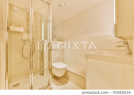 Flush toilet located between sink and shower in small tiled bathroom of contemporary apartment Flush toilet located between sink and shower in small tiled bathroom of contemporary apartment 95668816