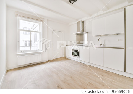 Interior of empty white kitchen with windows and wooden parquet floor Interior of empty white kitchen with windows and wooden parquet floor 95669006