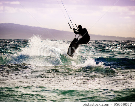 Kite surfer riding waves. Kiteboarding sport. 95669097