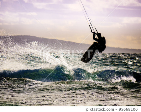Kite surfer riding waves. Kiteboarding sport. 95669100