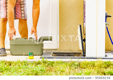 Man emptying caravan tank toilet cassette in dump station. Man emptying caravan tank toilet cassette in dump station. 95669238