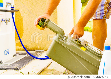 Man emptying caravan tank toilet cassette in dump station. Man emptying caravan tank toilet cassette in dump station. 95669267