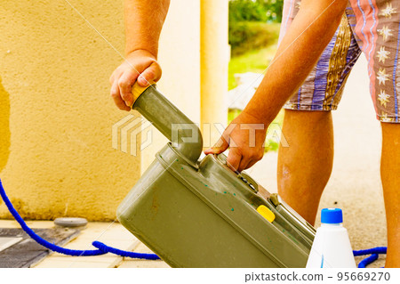 Man emptying caravan tank toilet cassette in dump station. 95669270