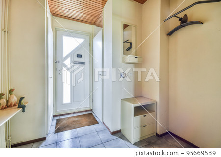 Room with door to balcony and narrow long corridor in perspective in modern house with ceiling beams 95669539