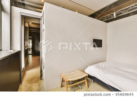 Home interior design of bedroom with bed and wooden wardrobe placed in corner near window in modern apartment 95669645