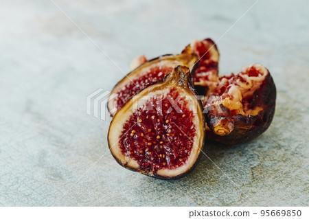 some ripe figs cut in halves on a table some ripe figs cut in halves on a table 95669850