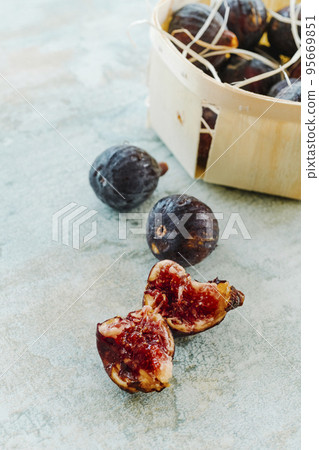 some ripe figs next to a wooden box full of figs some ripe figs next to a wooden box full of figs 95669851