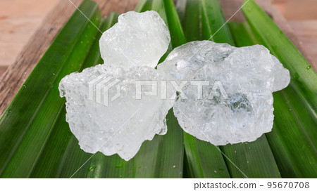 Crystal clear alum cubes or Potassium alum on green leaf Chemical compound substance Concept for beauty spa and underarm treatment industrial Crystal clear alum cubes or Potassium alum on green leaf Chemical compound substance Concept for beauty spa and underarm treatment industrial 95670708