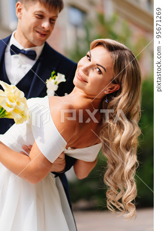 stylish newlyweds. groom and bride in traditional wedding clothes dance in park 95671269