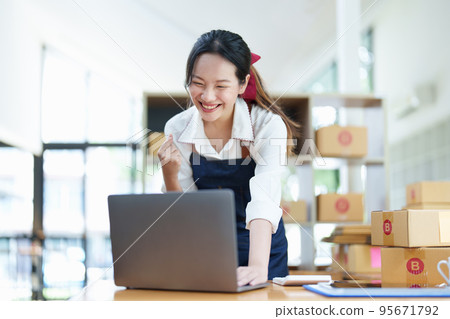 Starting small business entrepreneur of independent Asian woman smiling using computer laptop with cheerful success of online marketing package box items and SME delivery concept. Starting small business entrepreneur of independent Asian woman smiling using computer laptop with cheerful success of online marketing package box items and SME delivery concept. 95671792