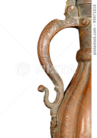 A close up of a handle of an antique copper jug with artistic chasing and engraving 95671818
