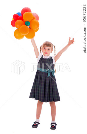 schoolgirl with balloons. Adorable little schoolgirl with a happy smile keeps her arms crossed. The little schoolgirl looks good in her school uniform. A pretty schoolgirl with long dark hair and a 95672228