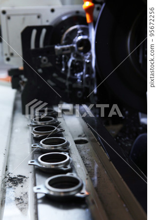 Manufacture of bearings. Details of new bearings on the machine. Concept of the industrial industry. Selective focus. Vertical photo.Harmful production. Manufacture of bearings. Details of new bearings on the machine. Concept of the industrial industry. Selective focus. Vertical photo.Harmful production. 95672256