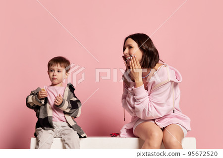 Play. Portrait of young woman and little boy, mother and son isolated on pink studio background. Mother's Day celebration. Concept of family, childhood, motherhood Play. Portrait of young woman and little boy, mother and son isolated on pink studio background. Mother's Day celebration. Concept of family, childhood, motherhood 95672520