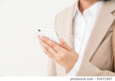 Middle business woman who operates a smartphone 95672867