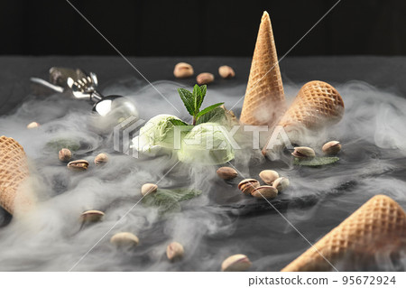 Gourmet chocolate and pistachio ice cream served on a stone slate over a black background. 95672924