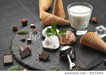 Gourmet creamy and chocolate ice cream served on a stone slate over a black background. Gourmet creamy and chocolate ice cream served on a stone slate over a black background. 95672943