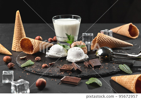 Gourmet chocolate and creamy ice cream served on a stone slate over a black background. Gourmet chocolate and creamy ice cream served on a stone slate over a black background. 95672957