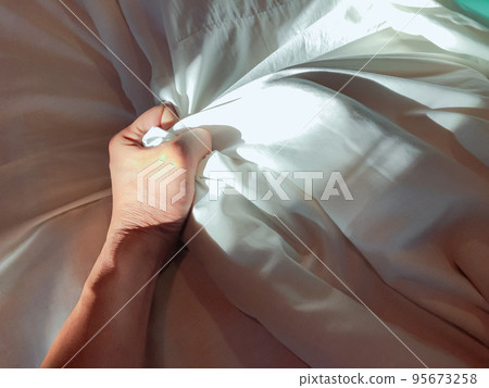 The man's hand pulled the white sheets, Hand mauled the white sheets on the bed, hands of a doctor with patient in the hospital, doctor with patient. The man's hand pulled the white sheets, Hand mauled the white sheets on the bed, hands of a doctor with patient in the hospital, doctor with patient. 95673258