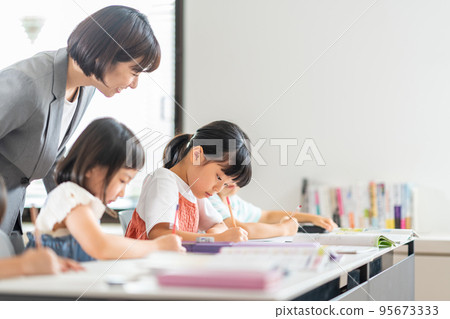 Elementary school students and teachers studying in the classroom. 95673333