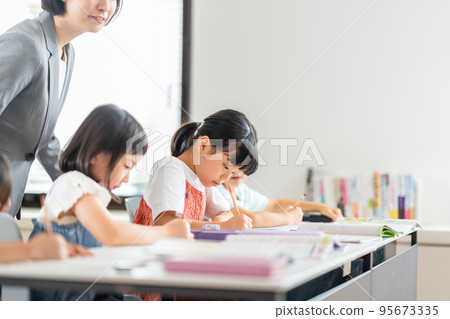 Elementary school students and teachers studying in the classroom. 95673335