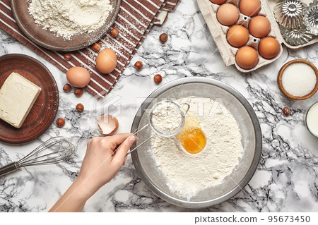 Close-up shot. Top view of a baker cook place, hands are working with a raw dough on the marble table background. 95673450