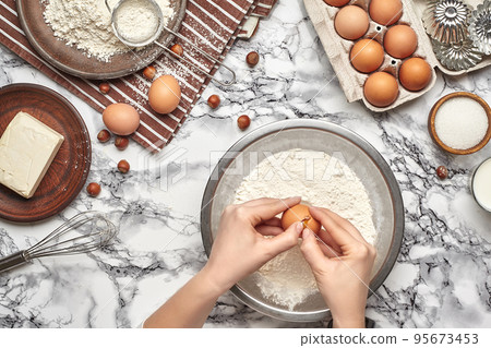 Close-up shot. Top view of a baker cook place, hands are working with a raw dough on the marble table background. 95673453