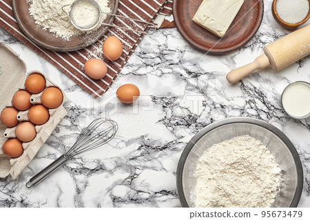 Close-up shot. Top view of a baking ingredients and kitchenware on the marble table background. Close-up shot. Top view of a baking ingredients and kitchenware on the marble table background. 95673479