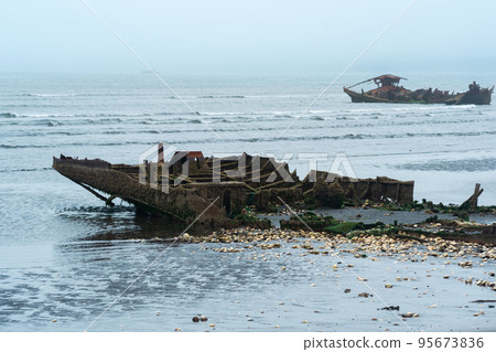 remains of a wrecked ships on a foggy seashore remains of a wrecked ships on a foggy seashore 95673836