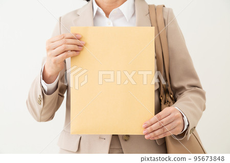 拿著有文件的信封的中間女性女實業家 95673848