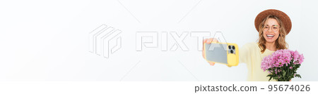 Happy young woman with bouquet taking selfie 95674026