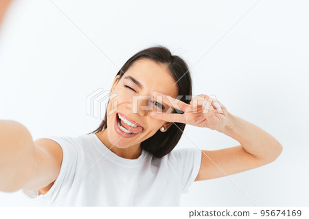 Young woman taking selfie portrait having fun Young woman taking selfie portrait having fun 95674169