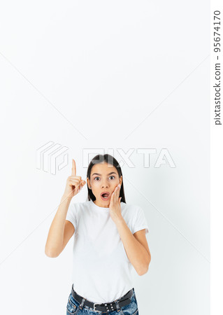 Amazed young woman pointing her finger up Amazed young woman pointing her finger up 95674170