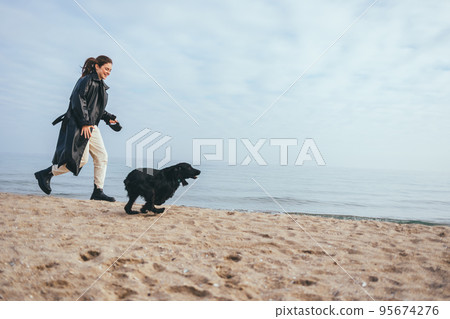 Young woman and her dog black cocker spaniel running 95674276