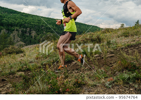 male runner running down mountain trail male runner running down mountain trail 95674764