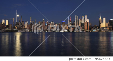 New York City skyline at night including the moon and nice reflection into Hudson River, USA 95674883