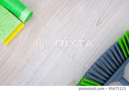 Cleaning service concept. Cleaning set with green tools on light wooden background. Top view cleaning accessories. Cleaning service concept. Cleaning set with green tools on light wooden background. Top view cleaning accessories. 95675115